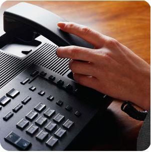 image of hand hanging up phone on desk